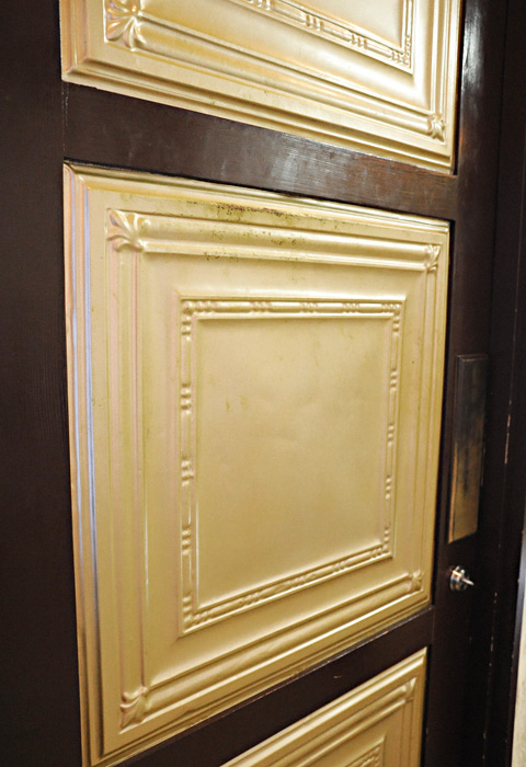 ブリキの天井材をはめ込んだドア。外と中でドアの色を変えて。